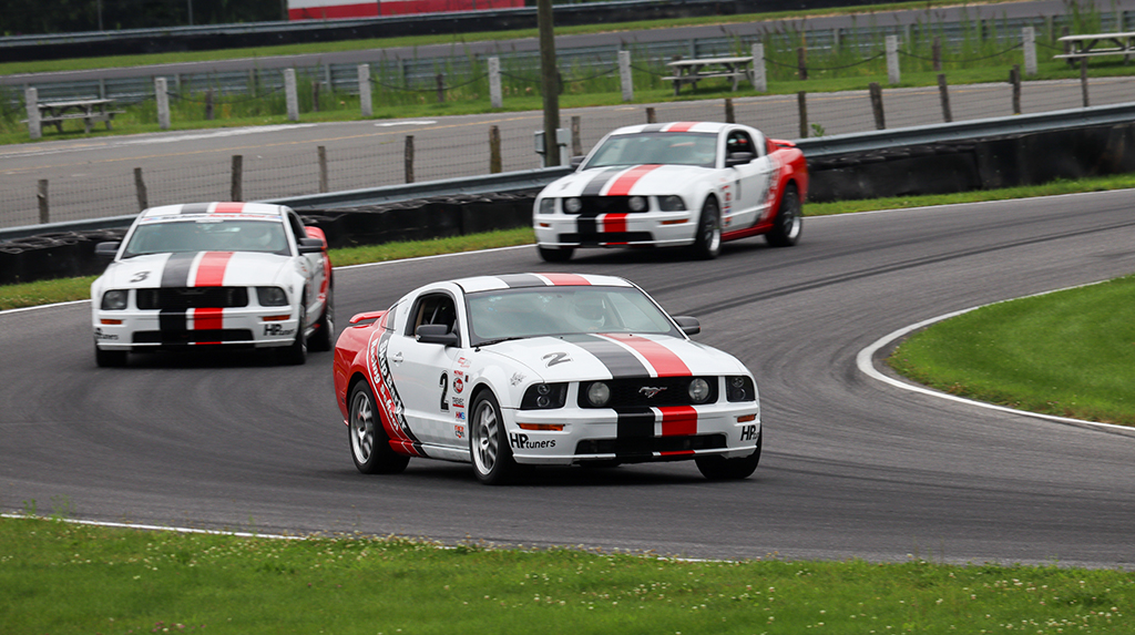 Skip Barber Racing School Mustang GTs on a road course.